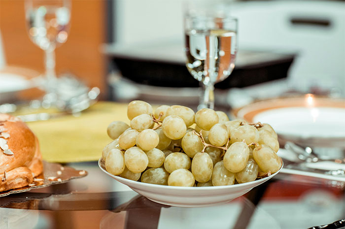 A bowl of green grapes on a dining table highlighting seemingly innocent things that can be deadly.