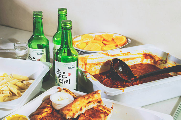 Green bottles and various foods on a table illustrating seemingly innocent things that are deadly in everyday dining.