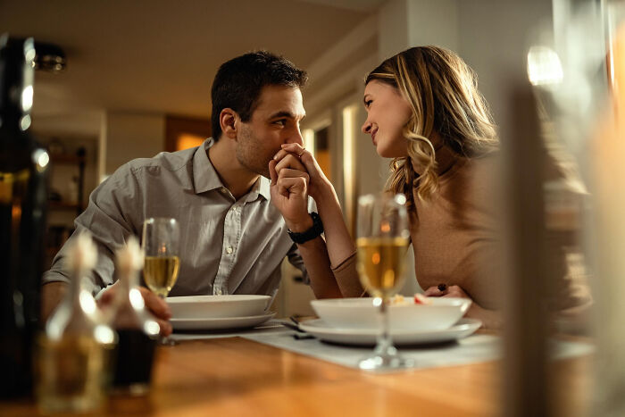 Couple sharing a tender moment at a dinner table, reflecting trust and patience from the good old days.