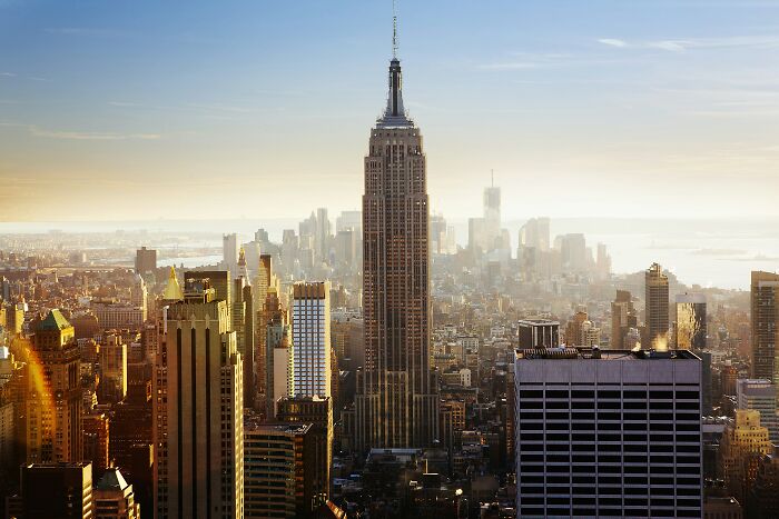 Daytime cityscape of New York with sunlight highlighting the Empire State Building, illustrating red flag signs in urban settings. - 7