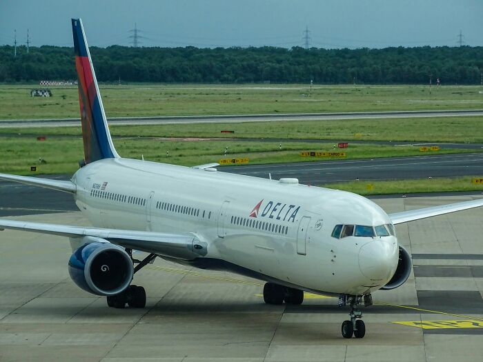 Delta airplane parked on the runway, representing a public flight experience and an uptight passenger's reality check.