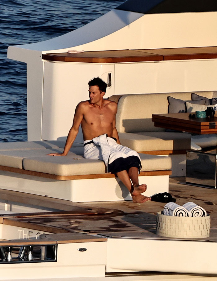 Tom Brady relaxing shirtless on a yacht during summer, linked to Sof&iacute;a Vergara's summer romance sparking spice reactions.