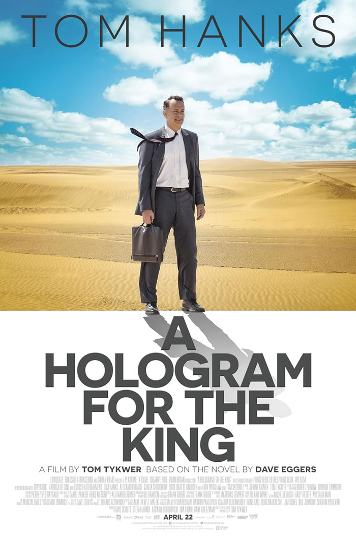 Tom Hanks standing in a desert holding a briefcase in the underrated movie A Hologram for the King.