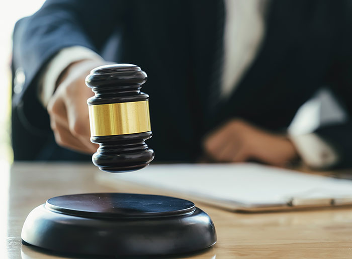 Judge in courtroom holding wooden gavel representing landmark domestic violence case victory for man against ex-girlfriend