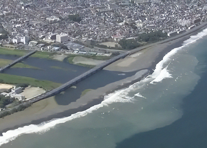 Aerial view of first tsunami waves slamming into coastal areas of Japan following a mega earthquake warning.