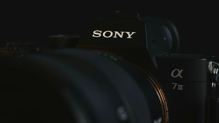 Close-up of a Sony alpha 7 III camera lens highlighting the equipment used for capturing rumors that turned out true.