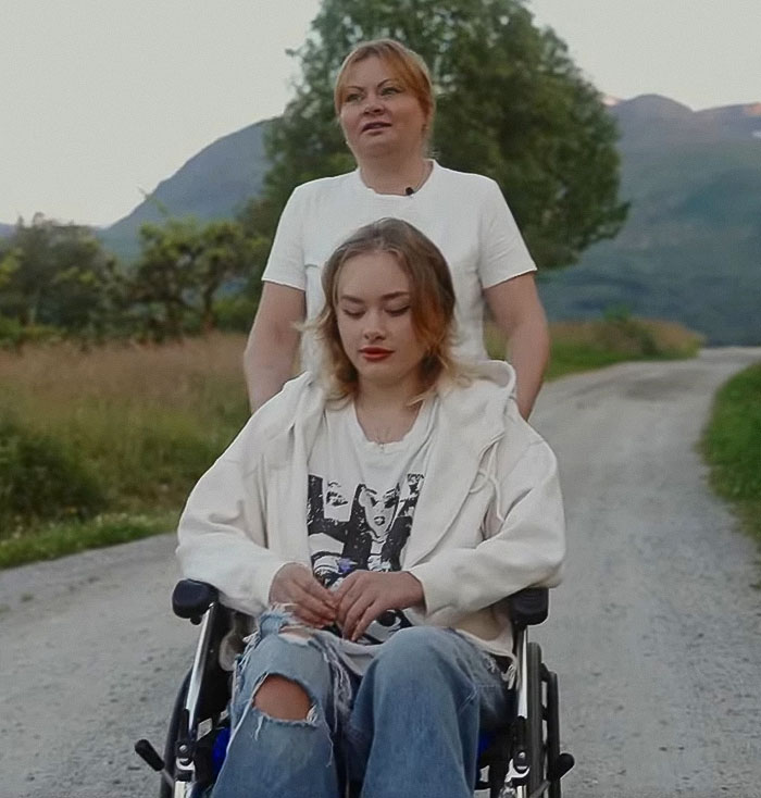 Young Ukrainian model in a wheelchair outdoors with a woman behind her, breaking silence after roadside injury in Dubai. - 3