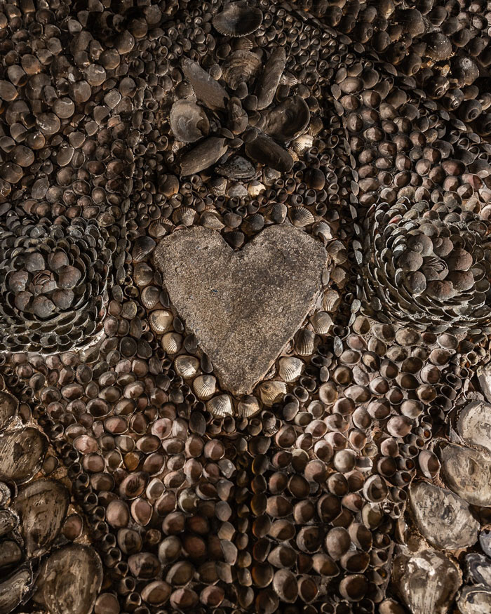 Heart shape surrounded by thousands of seashells inside a mysterious 70-foot underground grotto artwork.