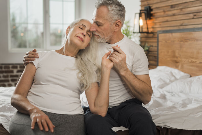 Elderly couple sharing a tender moment in a cozy room, illustrating calm despite unhinged family member wedding stress. - 6