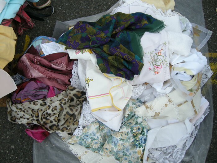 Pile of colorful and patterned fabrics and linens scattered outdoors, suggesting chaos from an unhinged family member wedding. - 24