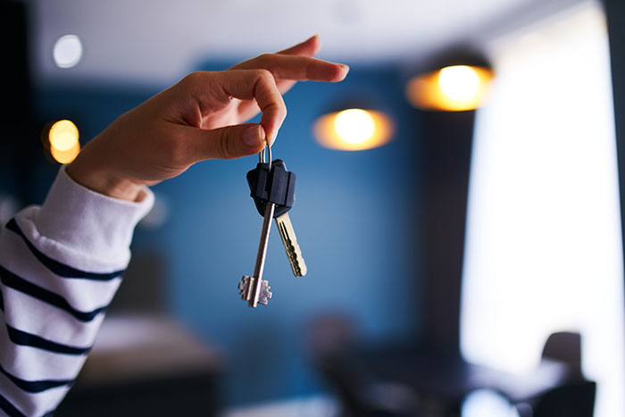 Hand holding keys indoors, illustrating life hacks that actually work and improve quality of life.