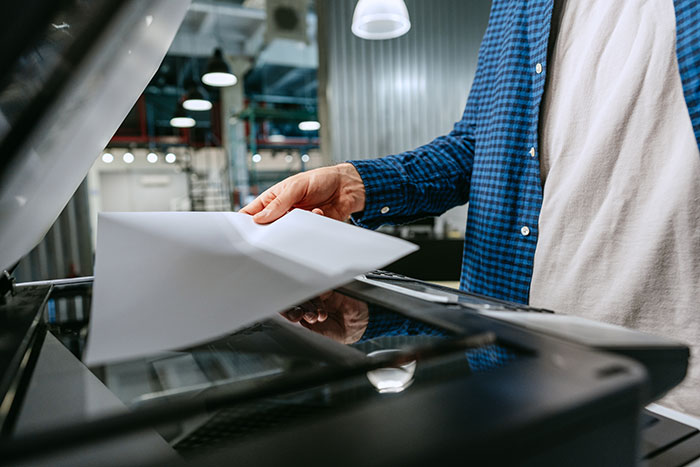 Person using a scanner in an office environment demonstrating practical life hacks that improve life quality.