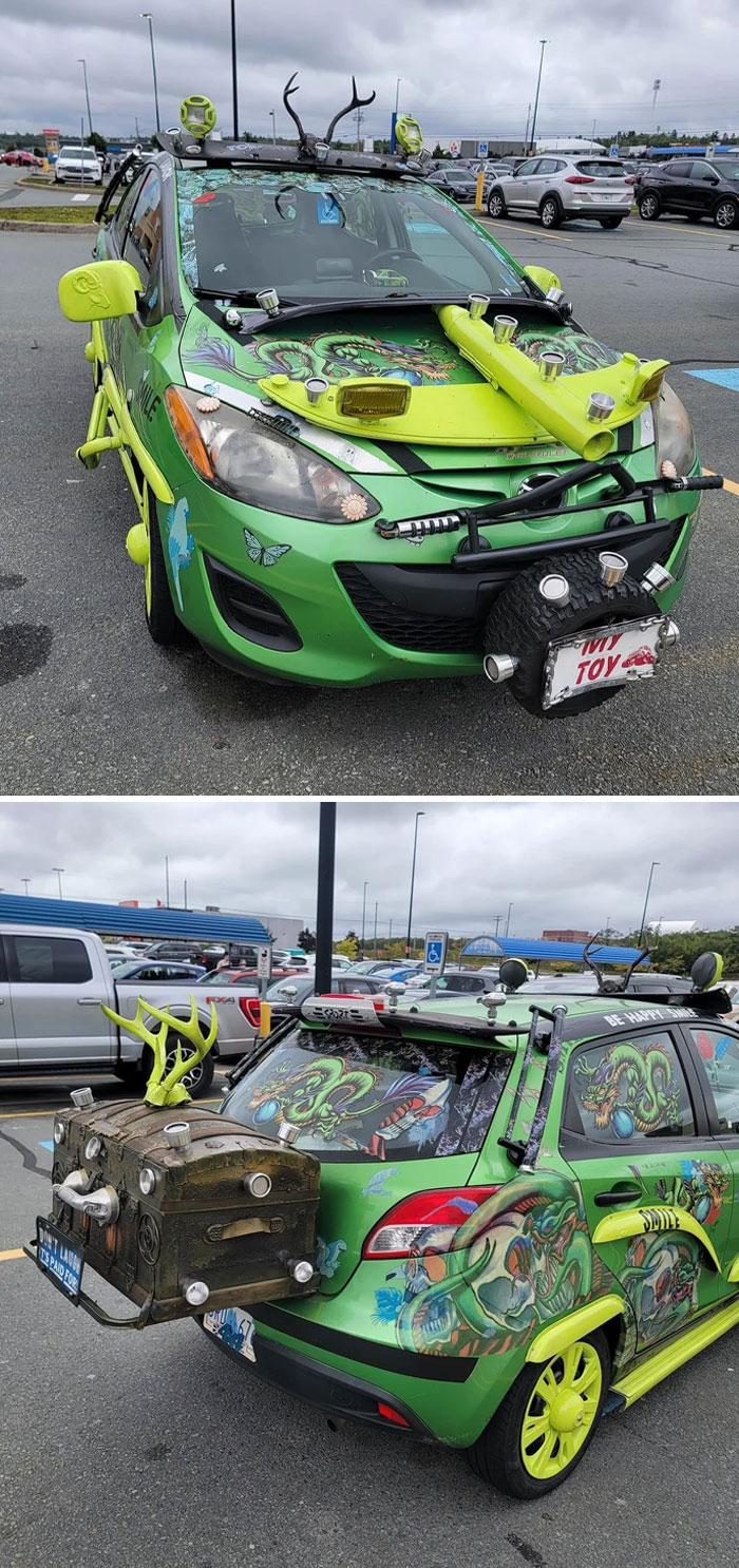 Green car with outrageous car mods including antlers, bright yellow accents, custom artwork, and unusual mounted objects.