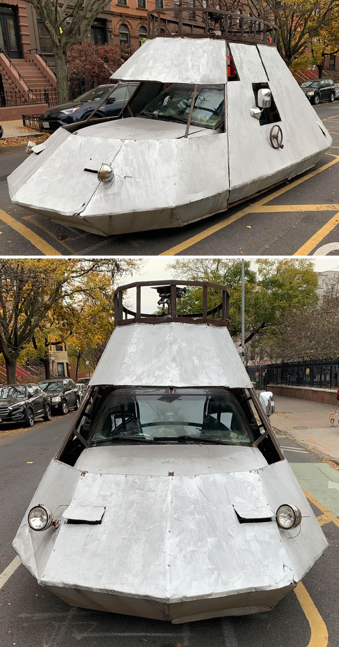 Outrageous car mod resembling a homemade armored vehicle with metal panels and unconventional design on a city street.