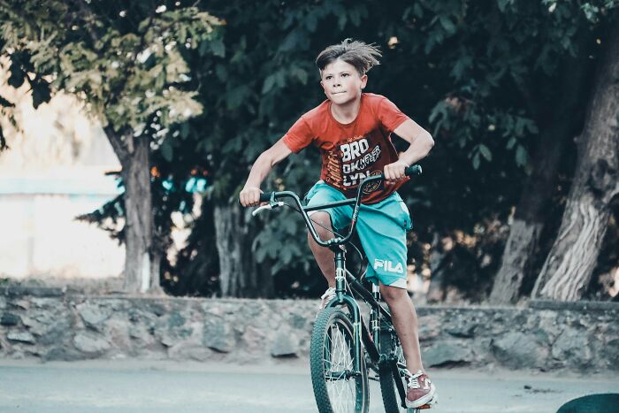 Boy with a focused expression riding a bike outdoors, illustrating moments when a gut feeling saved someone.