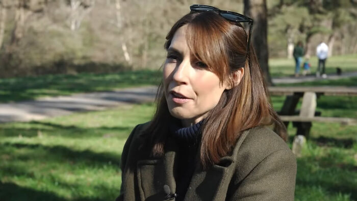 Woman in a green coat and sunglasses on head talking outdoors about celebrities many people love but can't stand