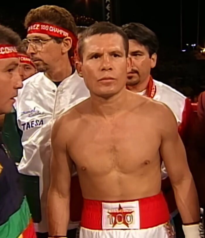 Boxer preparing for a match surrounded by his team, symbolizing the journey from poverty to super wealthy success.