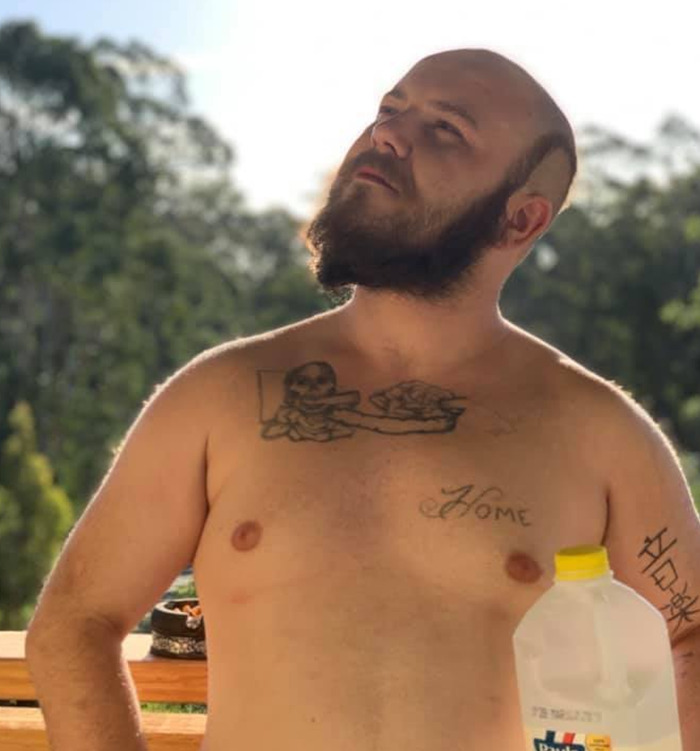 Shirtless man with beard posing outdoors near a container, related to vigilante who punished innocent dad wrongly accused of assault. - 7