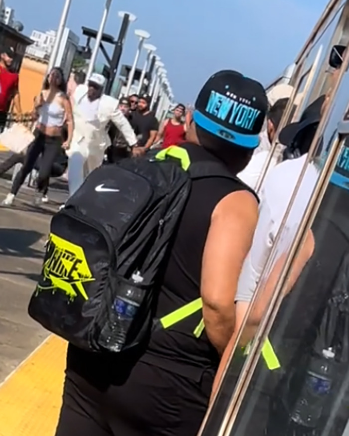 Men on subway platform delivering vigilante justice after a brute attacked a woman, crowd reacting in the background.