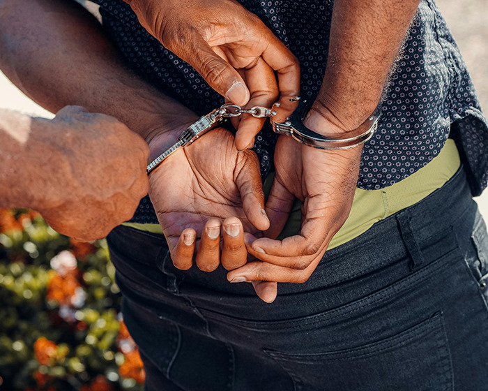 Man being handcuffed by police after men deliver vigilante justice following assault on subway platform.