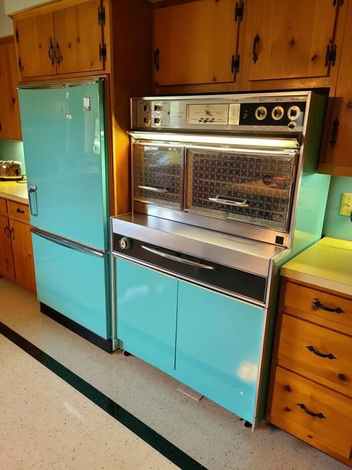 Vintage turquoise kitchen appliances and wooden cabinets showcasing quirky vintage things in a mid-century kitchen setting
