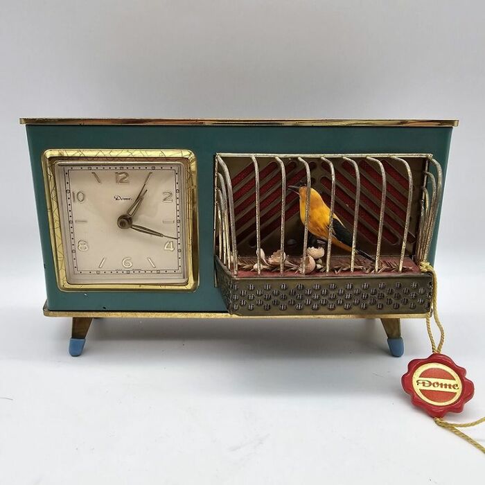 Vintage mechanical clock with an animated bird in a cage, showcasing unique and weird vintage things collection.