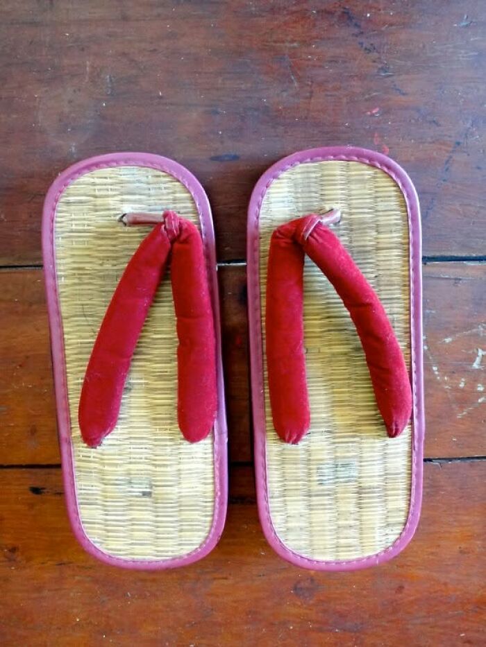 Pair of vintage sandals with red fabric straps on a wooden surface, showcasing unique vintage things style and design.
