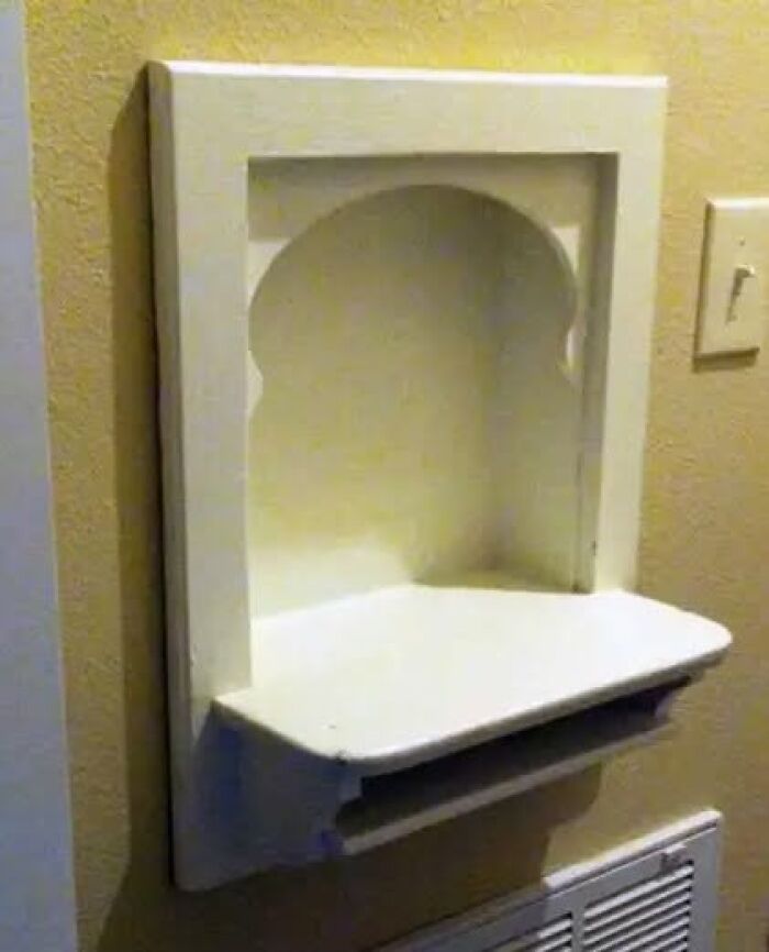 Vintage wall-mounted foldable shelf in white, showcasing a unique and weird vintage thing with practical design elements.