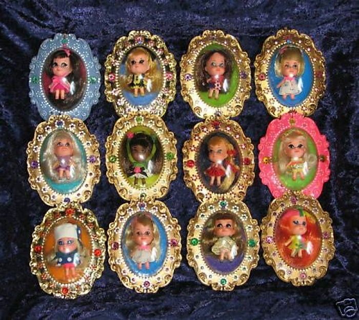 Collection of vintage tiny dolls displayed in ornate jeweled frames, showcasing weird and wonderful vintage things.