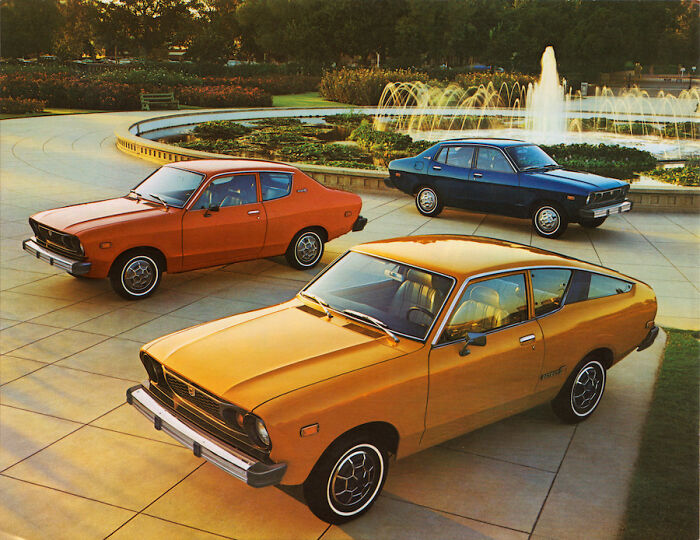 Three vintage cars parked near a fountain in a park, showcasing classic design and retro style elements.