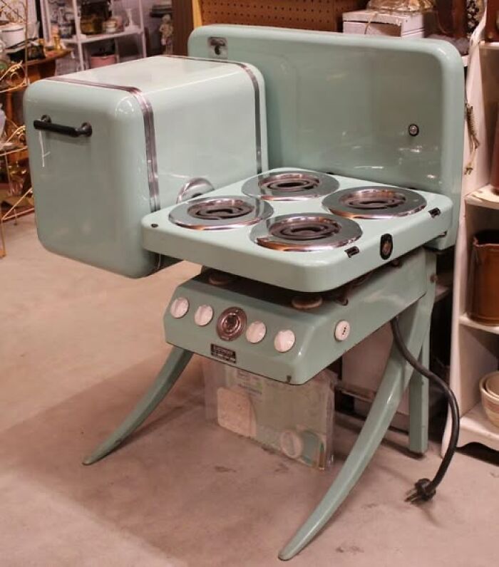 Vintage kitchen stove with unique retro design and curved legs, showcasing unusual vintage things from mid-20th century collections.