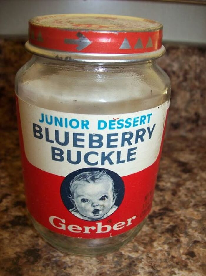 Vintage Gerber blueberry buckle dessert jar with retro label and weathered red lid on a kitchen countertop, vintage things.
