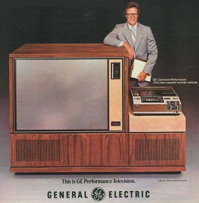 Vintage General Electric television and VHS player in wood cabinet with man in suit, showcasing vintage things as weird and wonderful.