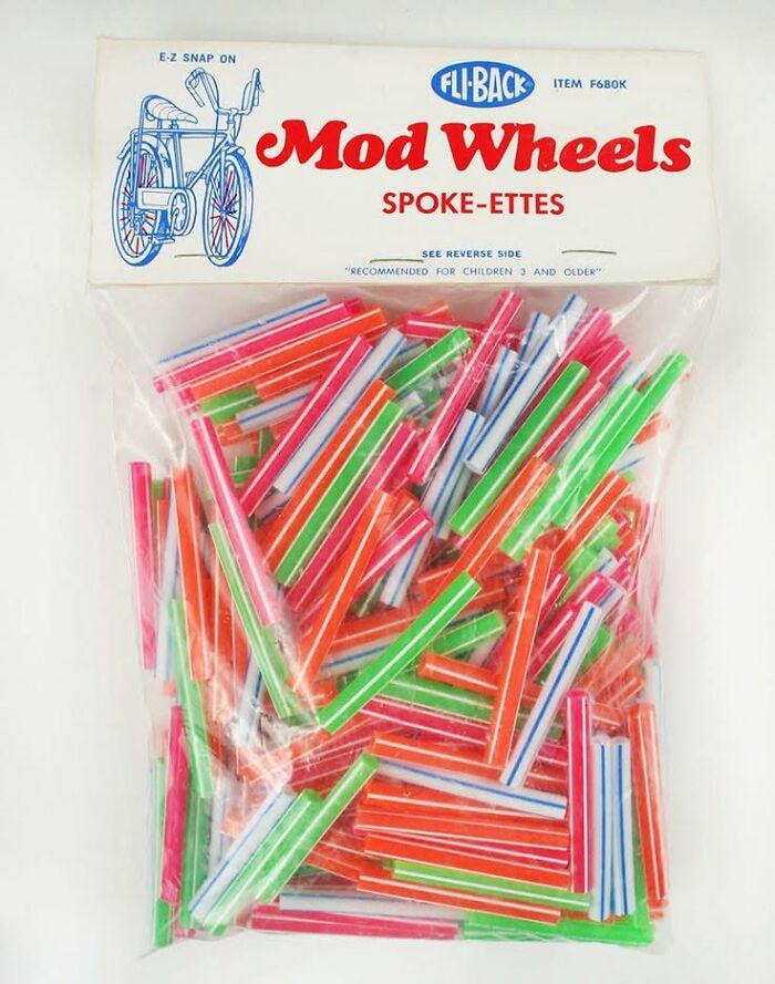 Vintage Mod Wheels spoke-ettes in bright red, green, blue, and pink colors packaged for children's bicycle decoration.