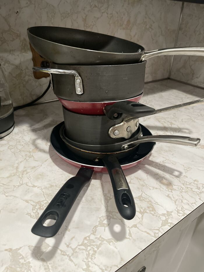 Stack of dirty pots and pans piled on a kitchen counter, illustrating common roommate problems from Reddit tales.