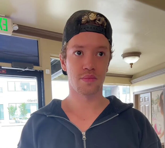 Young man wearing a black cap and hoodie inside a building, illustrating habits some netizens find really creepy. - 23