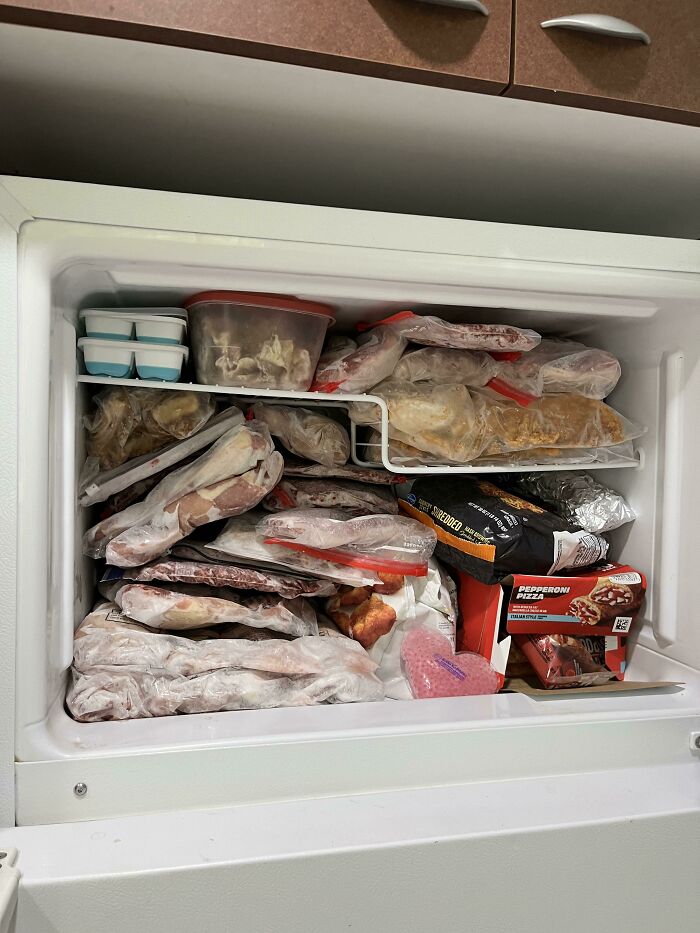 Frozen food packed tightly in a freezer, illustrating a common roommate challenge in shared living spaces.