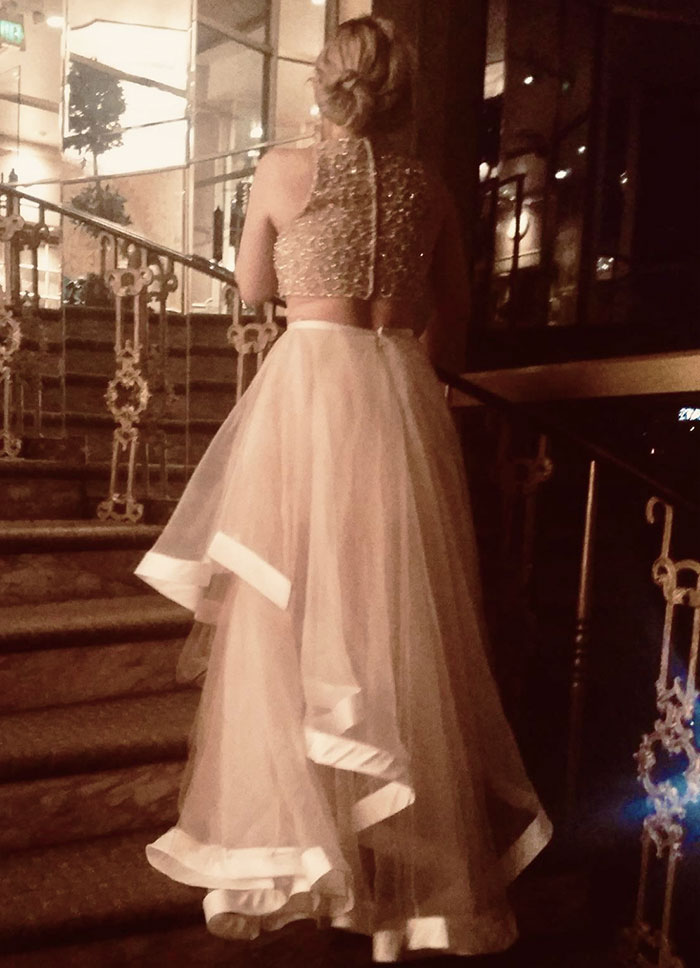 Woman in a glittery top and flowing white skirt at a wedding, dressed like the bride, creating a horribly awkward moment. - 1