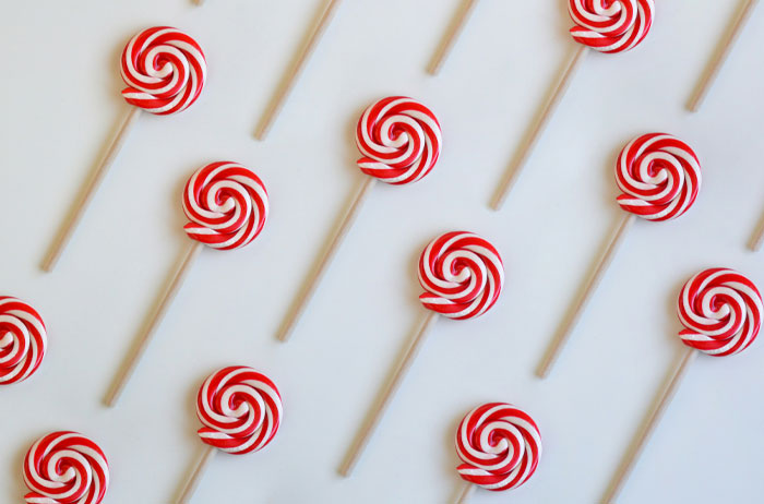 Red and white swirled lollipops arranged diagonally, representing American foods banned in other countries.