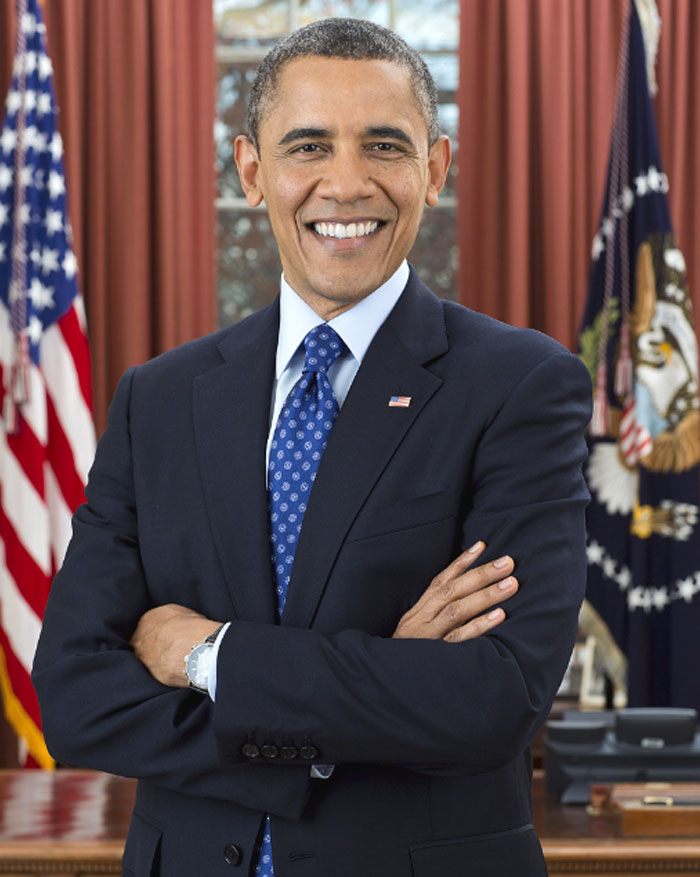 Former US president Barack Obama smiling confidently in the Oval Office, representing highest IQ in US presidents ranked list.