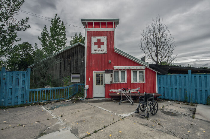 Red first aid building with vintage wheelchair and stretcher outside under cloudy sky, representing thank you notes era fading away.