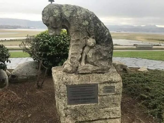 Stone sculpture of a bear holding a cub in a peaceful outdoor setting, showcasing the wonderful world of nature.