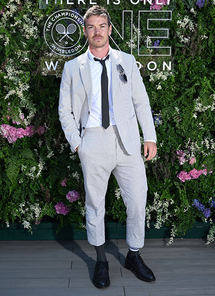 Man in a striped suit and black tie posing at Wimbledon 2025 with floral backdrop featuring best and worst celebrity looks.