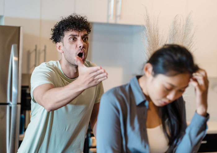 Man demands prenup, angrily gesturing toward woman who looks upset, depicting a tense negotiation scene with insurance stakes.