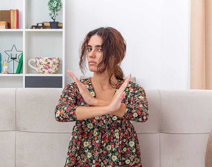 Woman sitting on couch with arms crossed in refusal, expressing refusal to be organ donor for mom's obnoxious bestie - 16