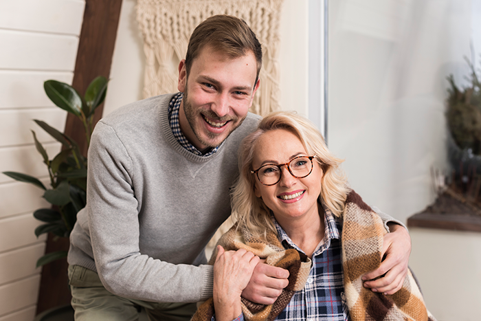 Woman smiling and sitting with a young man, illustrating a refusal to be an organ donor for mom's bestie. - 6