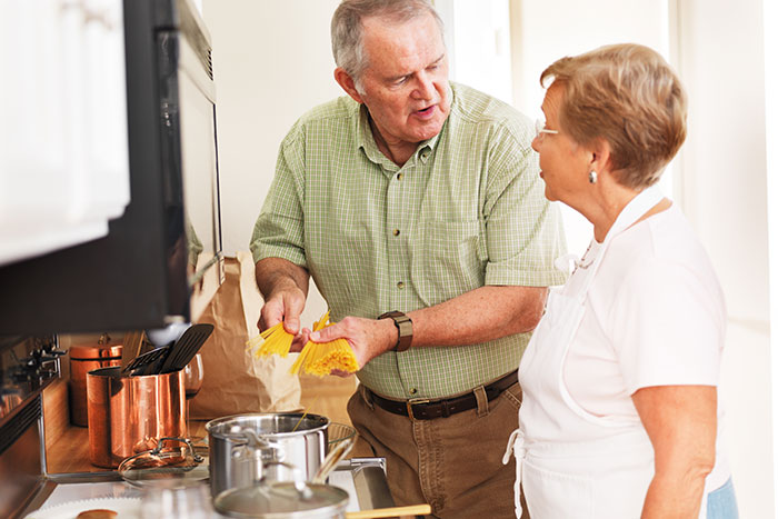 Older couple in kitchen preparing pasta, depicting BF&rsquo;s parents talking about woman who is shocked and wants to avoid them.