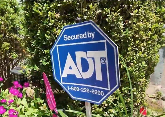 Yard with ADT security sign surrounded by plants, related to woman discovering phone buried in her yard. Yard with ADT security sign surrounded by plants, related to woman discovering phone buried in her yard.