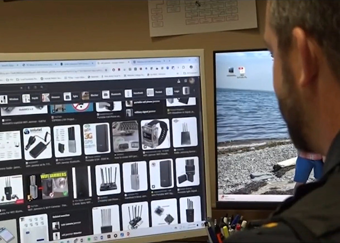 Man researching phone jammer devices on computer screen amid police warning of disturbing new trend. Man researching phone jammer devices on computer screen amid police warning of disturbing new trend.