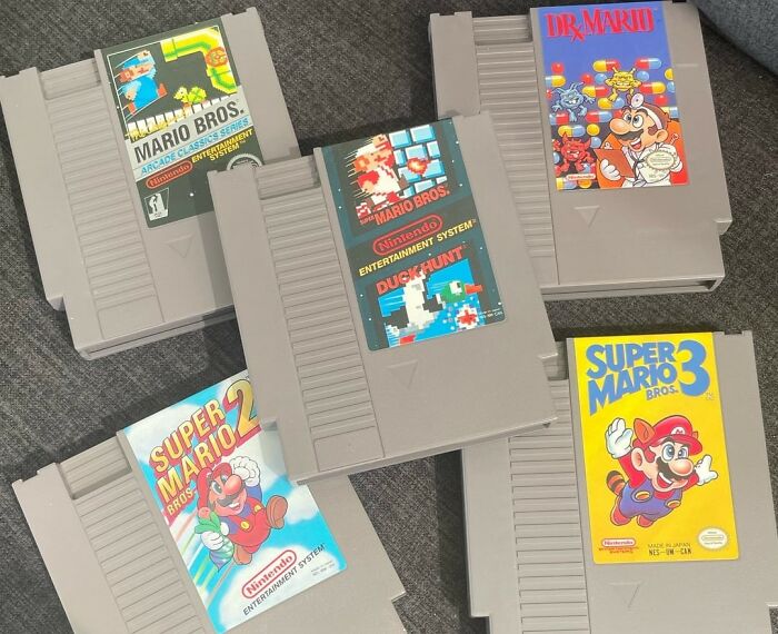 Collection of vintage Nintendo game cartridges representing toys collected to cope with childhood trauma. - 9